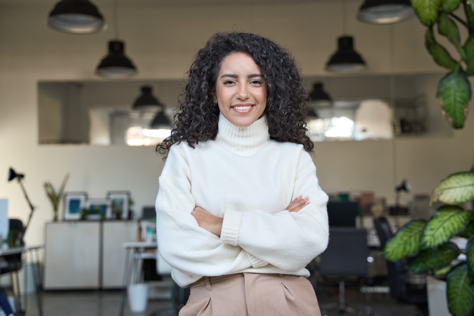 Young smiling Latina business woman manager standing in office, portrait.